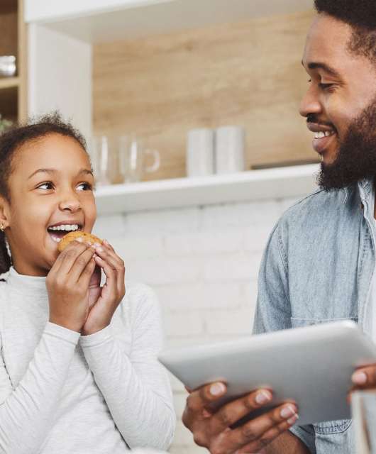 girl-eating-cookie-dad-on-ipad